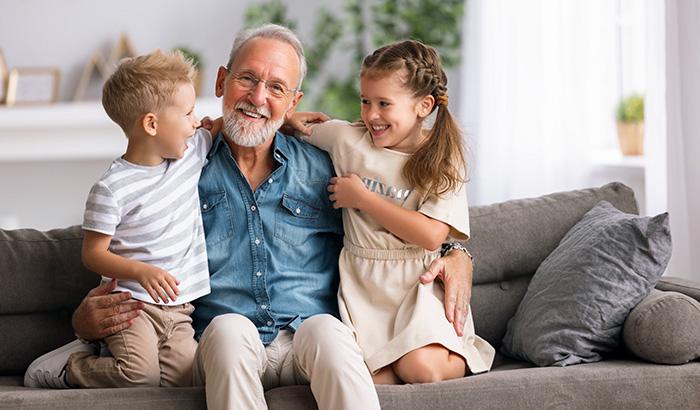 Grandfather smiling and able to hear grandchildren with hearing aid